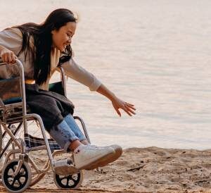 A woman in a wheelchair on the beach.