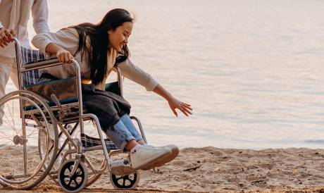 A woman in a wheelchair on the beach.
