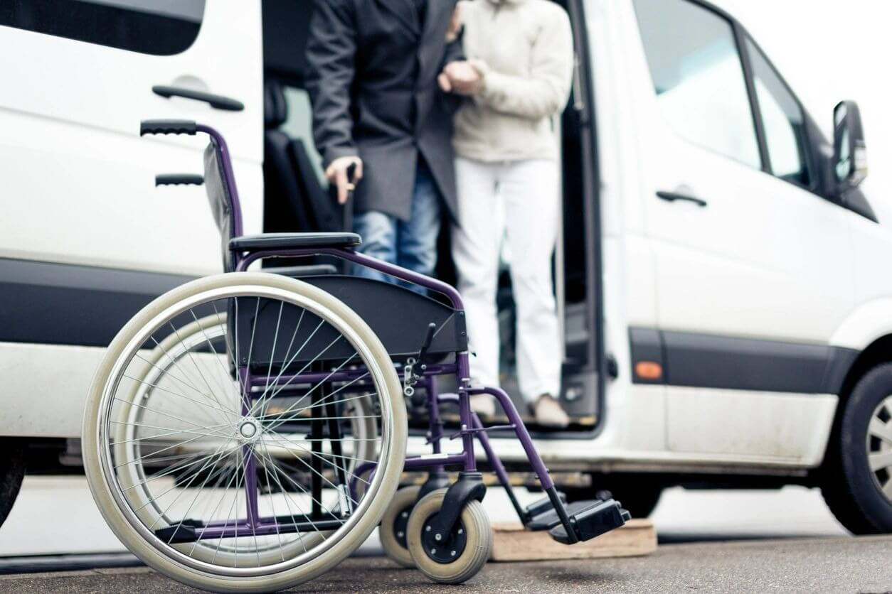 A wheelchair parked in front of a van.
